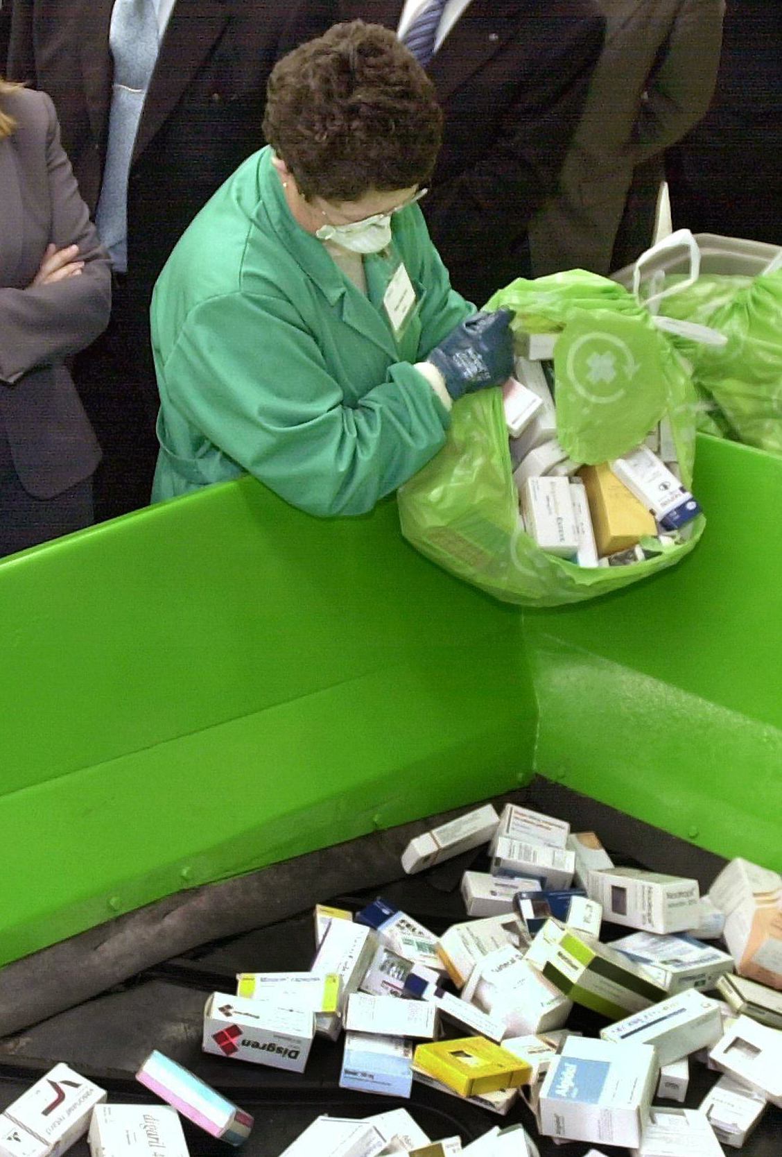 Una empleada vierte los medicamentos recogidos por colaboración ciudadana en un contenedor de las plantas de reciclaje SIGRE. EFE/archivo/Lavandeira jr