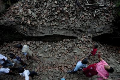 Residentes caminan sobre los escombros de su hogar derruido por el seísmo.EFE/Narendra Shrestha