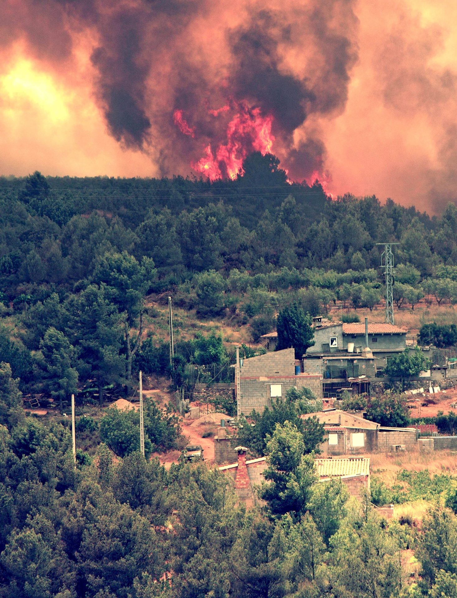 Las llamas se aproximan a las viviendas en la localidad valenciana de Turis, uno de los cinco municipios afectados por el incendio forestal de Cortes de Pallás. EFE/Manuel Bruque