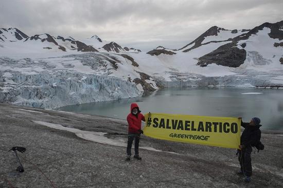 Fotografía cedida hoy, martes 16 de julio de 2013, donde se ve al cantante español Alejandro Sanz (i) sosteniendo una pancarta en la zona en la zona de Kulusuk (Groenlandia). EFE/PEDRO ARMESTRE/