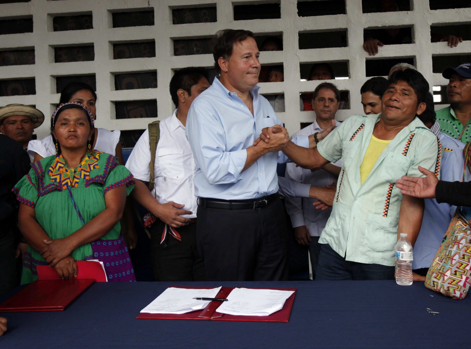 La cacica general de la comarca Ngäbe Buglé, Silvia Carrera (i), el presidente de Panamá, Juan Carlos Varela (c) y el cacique regional, Jeremías Montero (d), tras la firma este lunes del acuerdo de la hidroeléctrica en Llano Tugrí (Panamá). EFE/Alejandro Bolívar
