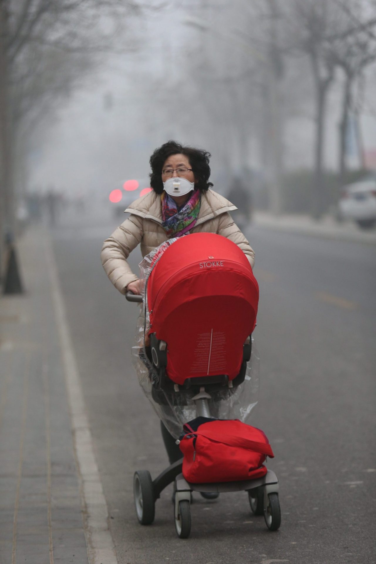 WU06. PEKÍN (CHINA), 20/12/2016.- Una mujer camina con una mascara debido a la bruma por contaminación hoy, martes 20 de diciembre de 2016, en Pekín (China). La grave contaminación atmosférica llegó a las 11 provincias y ciudades de China este 19 de diciembre, mientras que el índice de Calidad del Aire (AQI) se acercó a las PM2,5 (partículas) y alcanzó los 500 en la madrugada el 20 de diciembre en Pekín. EFE/WU HONG