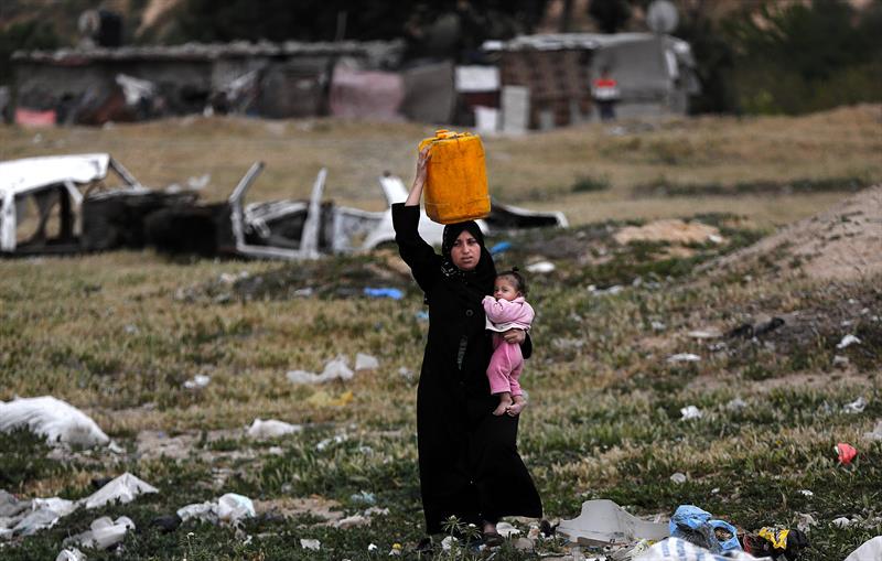 Niña palestina lleva un bidón de agua después de llenarla en una fuente pública del campamento de refugiados Khan Yunis de Gaza.