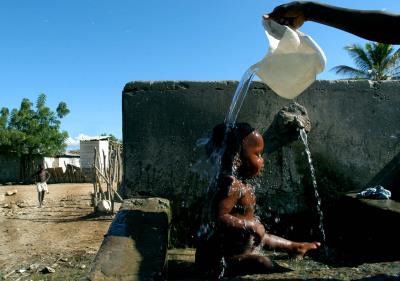 BARAHONA (REPÚBLICA DOMINICANA).- Foto de archivo de Lissette una pequeña Domínico-Haitiana, es lavada por su madre en la única llave con agua del Batey 5, lugar donde viven 200 familias. . EFE/Orlando Barría