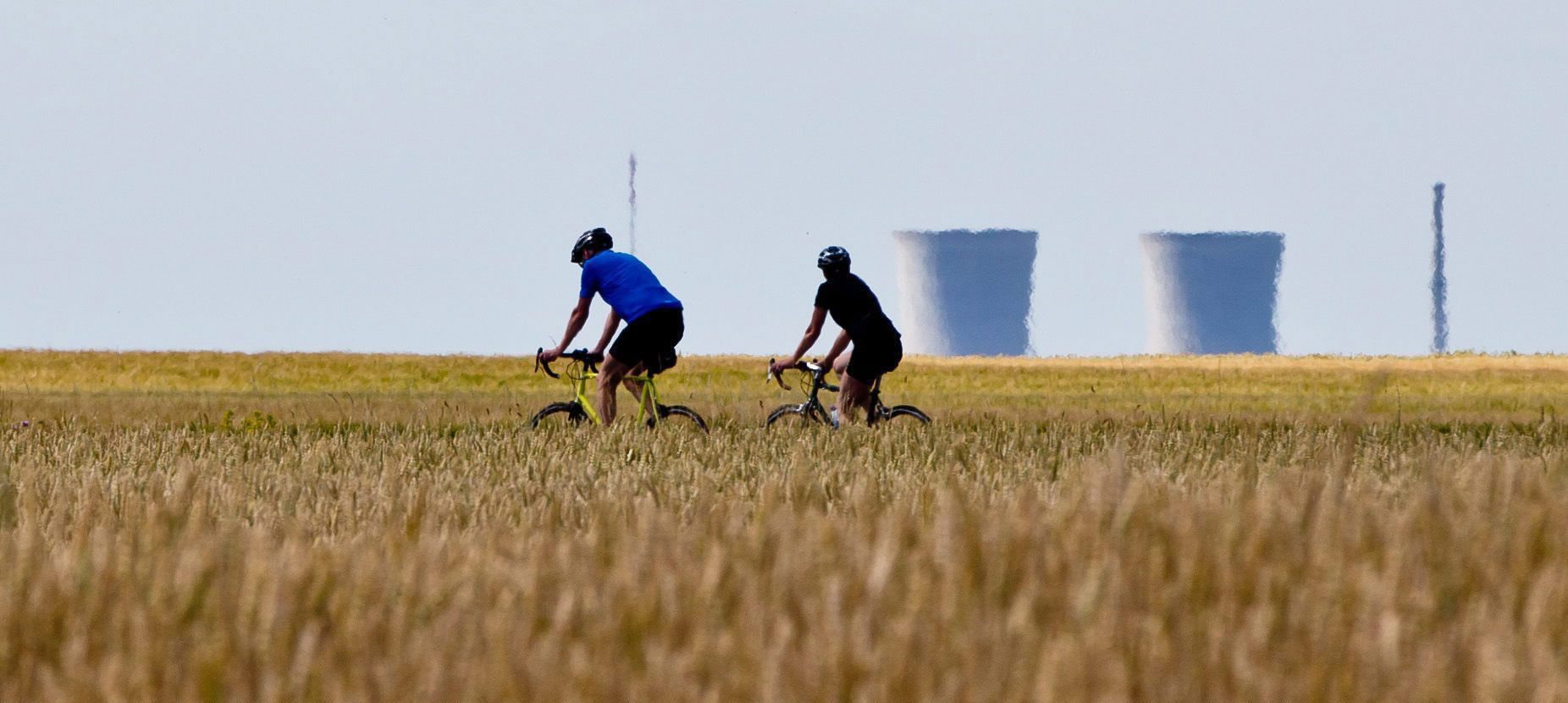 Dos ciclistas pasan por delante de las torres de la nuclear alemana de Grafenrheinfeld.