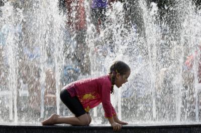 Un niño se refresca en una fuente de Melbourne (Australia) este verano austral.