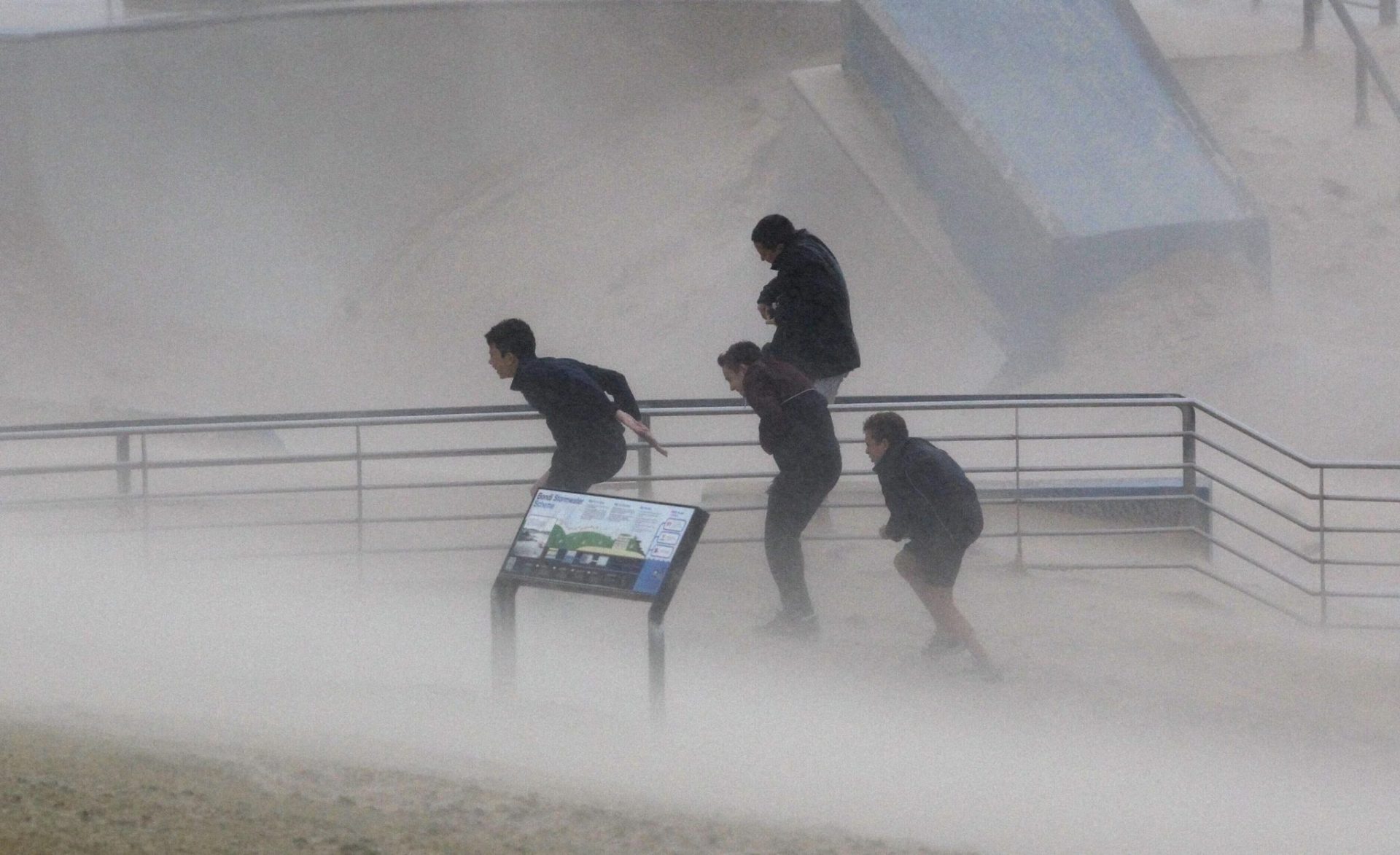 Varios chicos buscan refugio de los fuertes vientos en Bondi (Australia).