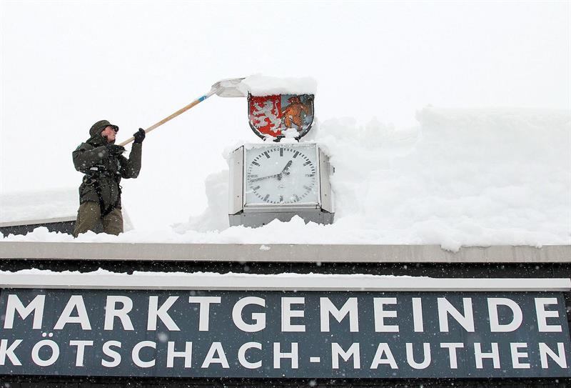 Un soldado limpia de nieve la chimenea de un edificio municipal de Koetschach-Mauthen, en la provincia de Carintia (Austria) este 2 de febrero de 2014.