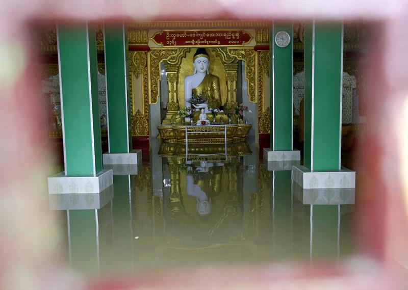 Una estatua de Buda se refleja en el agua dentro de un edificio, en la localidad de Kan Gyee.