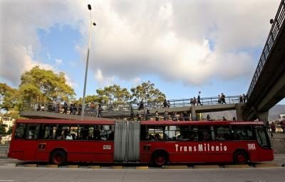 Decenas de personas ingresan a una estación de transporte masivo de Transmilenio en Bogotá.
