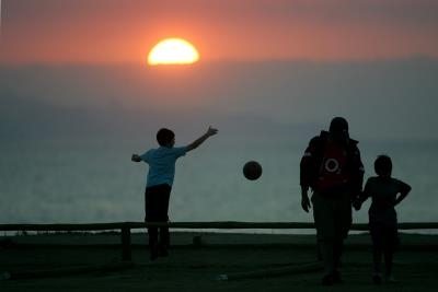 Unos niños juegan ante una puesta de sol en Viña del Mar (Chile).
