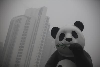 Una estatua de un oso panda entre una nube de contaminación, en el centro de Pekín (China).