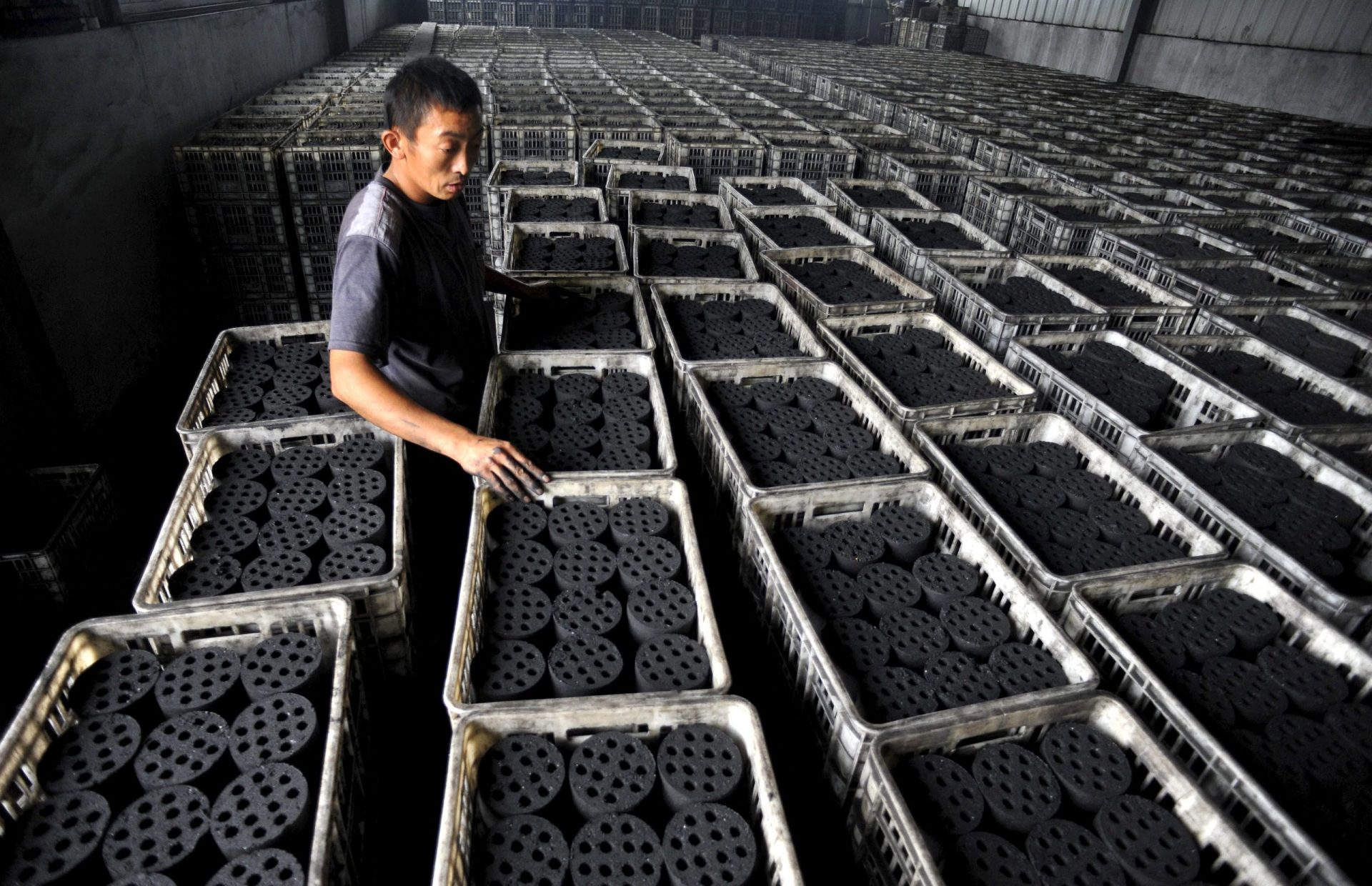 Un trabajador chino en un almacén de briquetas de carbón, la principal fuente de energía y combustible para la calefacción.