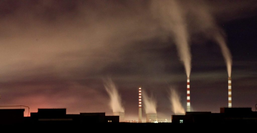 Chimeneas de una planta de energía de carbón emiten humo durante la noche en Changchun