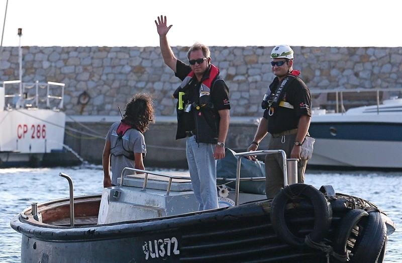 El ingeniero sudafricano Nick Sloane saluda mientras se dirige en un bote hacia el Costa Concordia, para dirigir las labores de traslado de la nave tras su reflotamiento. 