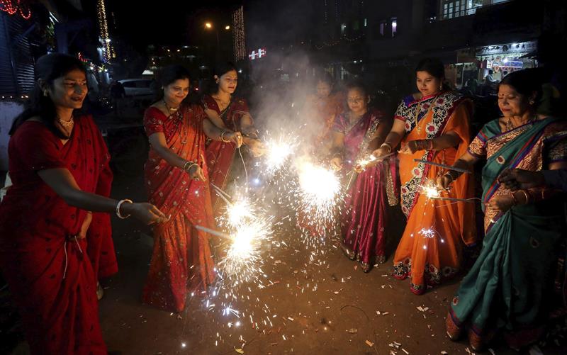Un grupo de mujeres enciende fuegos artificiales en el Diwali.