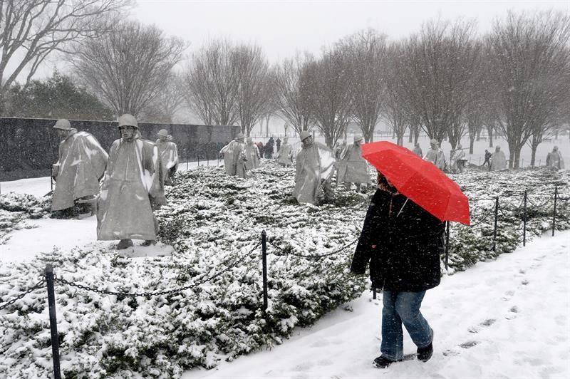 Una persona pasa frente al monumento dedicado a los Veteranos de la Guerra de Corea, durante una tormenta de nieve  en Washington D.C. (EEUU).