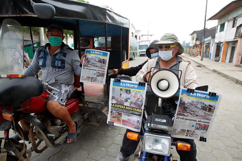 En medio de la desgracia, un hombre vende el periódico local en Pedernales. 
