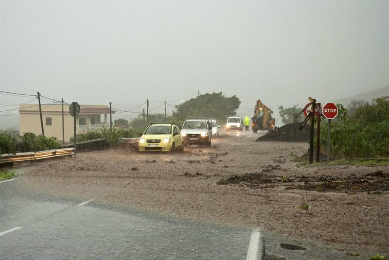 Varios vehículos circulan por una carretera de La Frontera, en el Hierro, durante la intensa lluvia registrada, con 200 litros/m2, este 2 de diciembre de 2013 en la isla canaria.