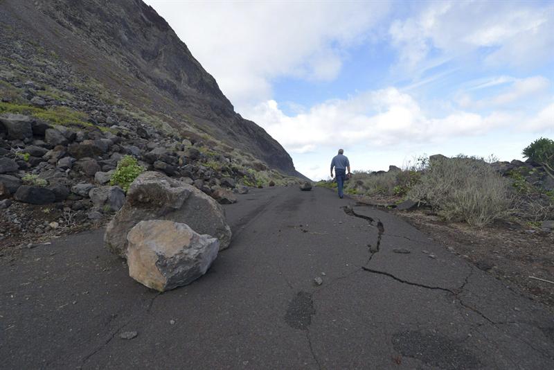 Un hombre camina entre las rocas desprendidas en la carretera de Arenas Blancas, por el terremoto de 5,1 grados de la escala Richter, registrado el 27 de diciembre de 2013 en la isla canaria de El Hierro.