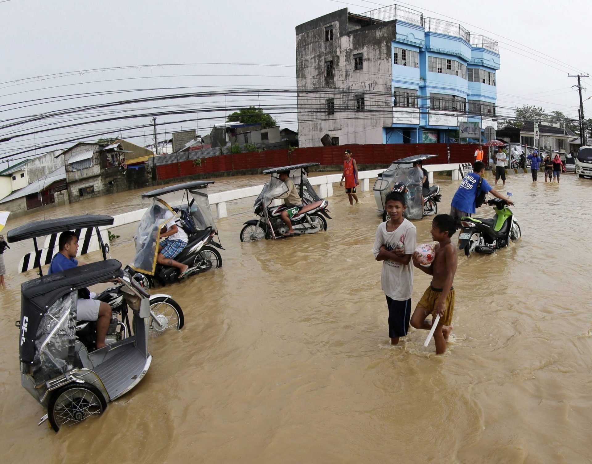 Varios ciudadanos de Cabanatuan sobre un puente inundado.
