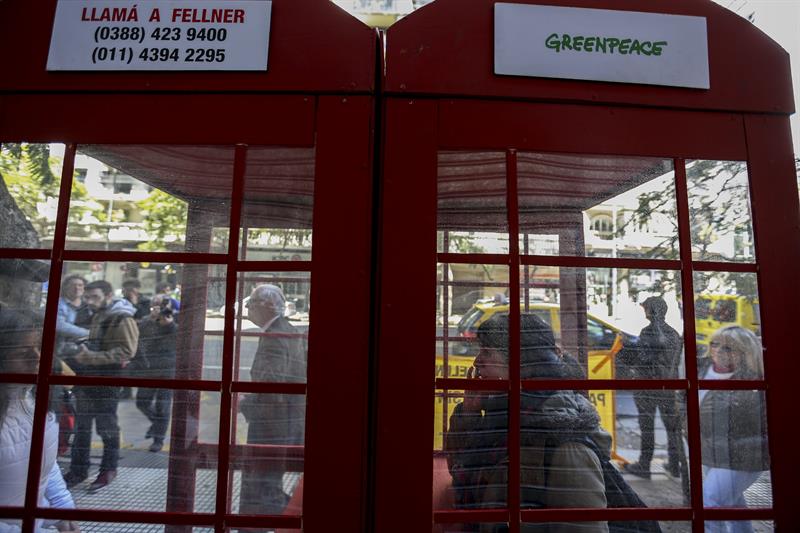 Activistas de Greenpeace son vistos hoy, viernes 16 de octubre de 2015, durante una protesta en la que han instalado cabinas telefónicas en Buenos Aires (Argentina)para llamar al Gobierno de la provincia de Jujuy y protestar por petroleras que operan en parque nacional. EFE/David Fernández