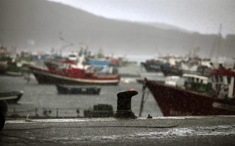 La flota pesquera amarrada en el puerto gallego de Fisterra bajo una intensa granizada.