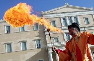 Un artista lanza fuego por la boca frente al Parlamento griego, en Atenas, para protestar contra el cambio climático