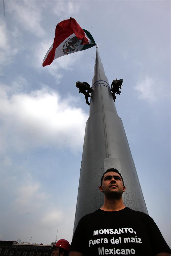 Vista de activistas de Greenpeace escalando una pancarta contra los transgénicos en lo alto del monumento que preside la plaza del Zócalo en la Ciudad de México. 
