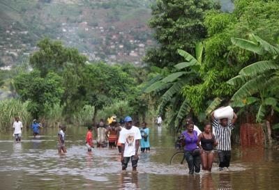 Haitianos caminan por una calle inundada por las fuertes lluvias