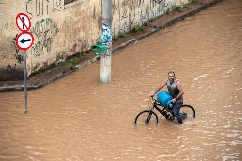 Un habitante camina por una calle afectada este lunes, tras las inundaciones producidas por un temporal en Sao Paulo (Brasil). Al menos siete personas murieron en la región metropolitana de Sao Paulo, la ciudad más poblada de Brasil, por un fuerte temporal que se registró desde la noche del domingo en la región, informaron fuentes oficiales. EFE/Sebastião Moreira