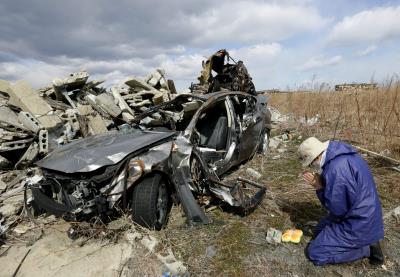Un ciudadano de Namie reza en 2014 ante los restos que dejó el accidente nuclear tras el tsunami. 