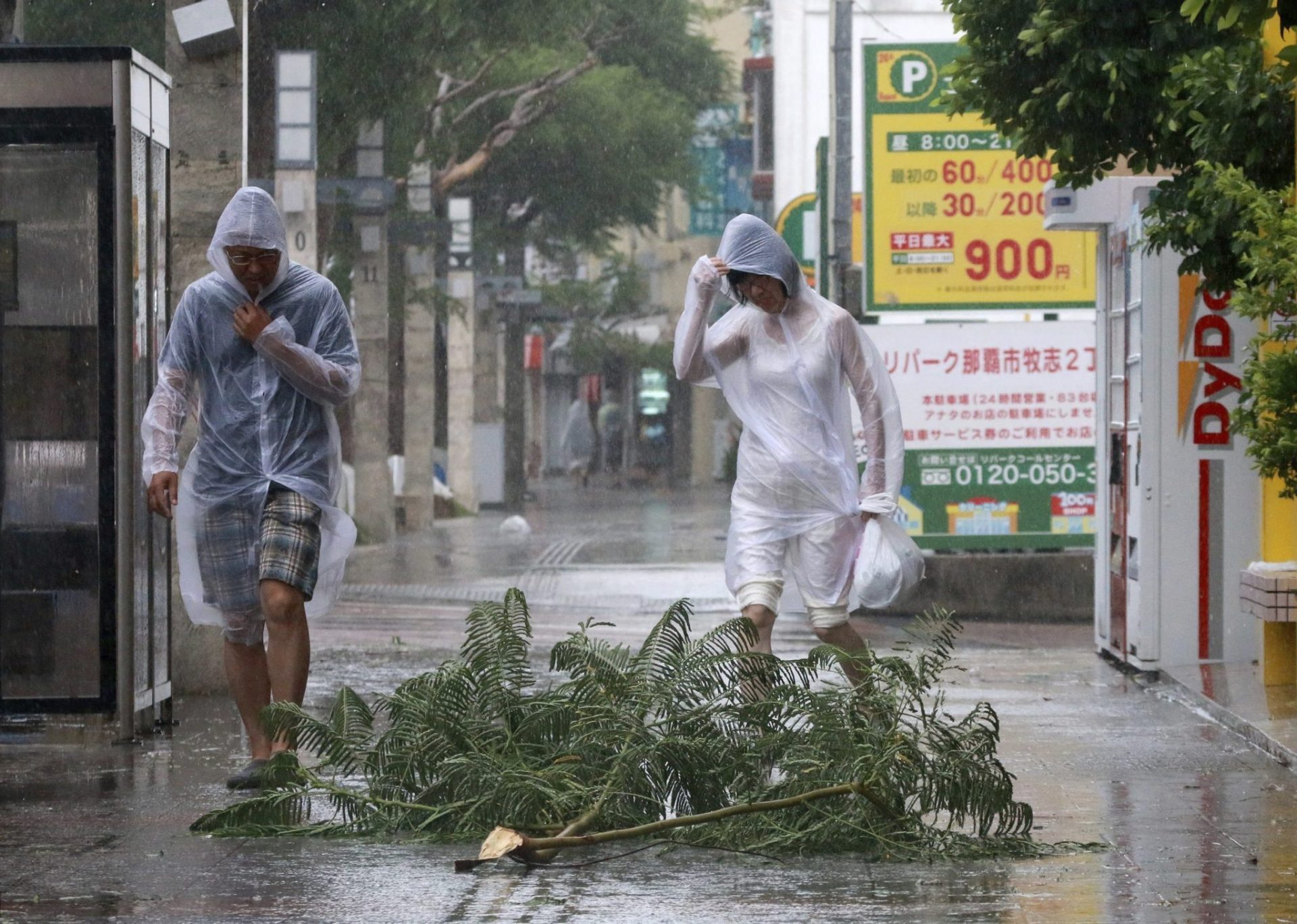 Dos personas evitan una rama caída en Naha, en la isla de Okinawa (Japón).