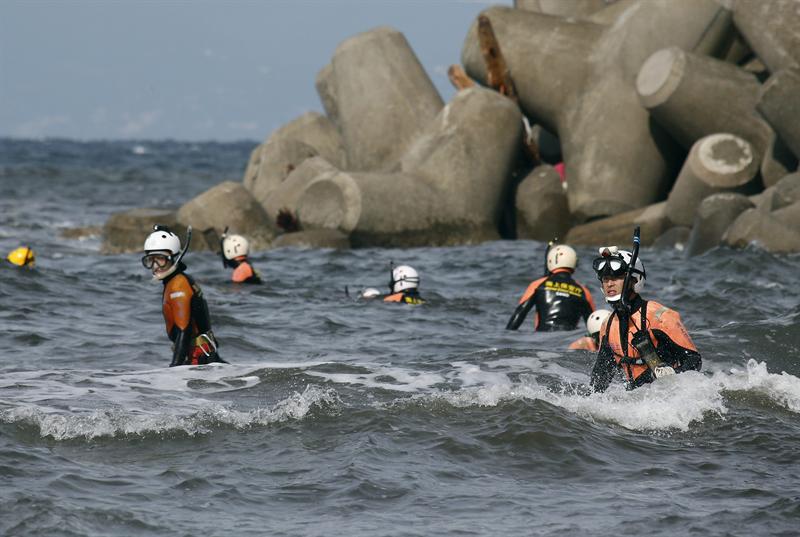 Buzos de la Guardia Costera buscan a los desaparecidos tras el paso del tifón "Wipha" en la isla de Oshima en Japón hoy.