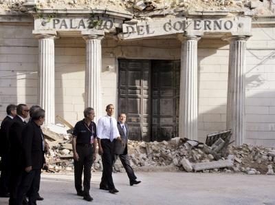 El exprimer ministro italiano Silvio Berlusconi, (d), y el presidente estadounidense Barak Obama, pasean por Onna, tras el terremoto de 2009. 