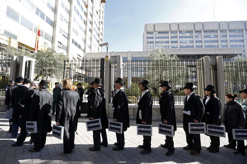 19/11/2014.- Miembros de la Plataforma por un Nuevo Modelo Energético, durante la manifestación que han realizado hoy en Madrid para reclamar al Gobierno que exija a las eléctricas la devolución de 3.400 millones de euros cobrados de más en concepto de costes de transición a la competencia (CTC). Los manifestantes han acudido vestidos de cobradores del frac a las sedes del Ministerio de Industria y de la patronal eléctrica Unesa, ambas ubicadas junto a la madrileña plaza de Cuzco. EFE/Javier Lizón