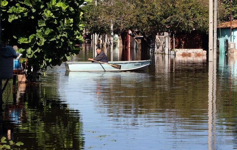 Un hombre transita en su bote en una calle inundada este 19 de junio de 2013, en un barrio de Asunción