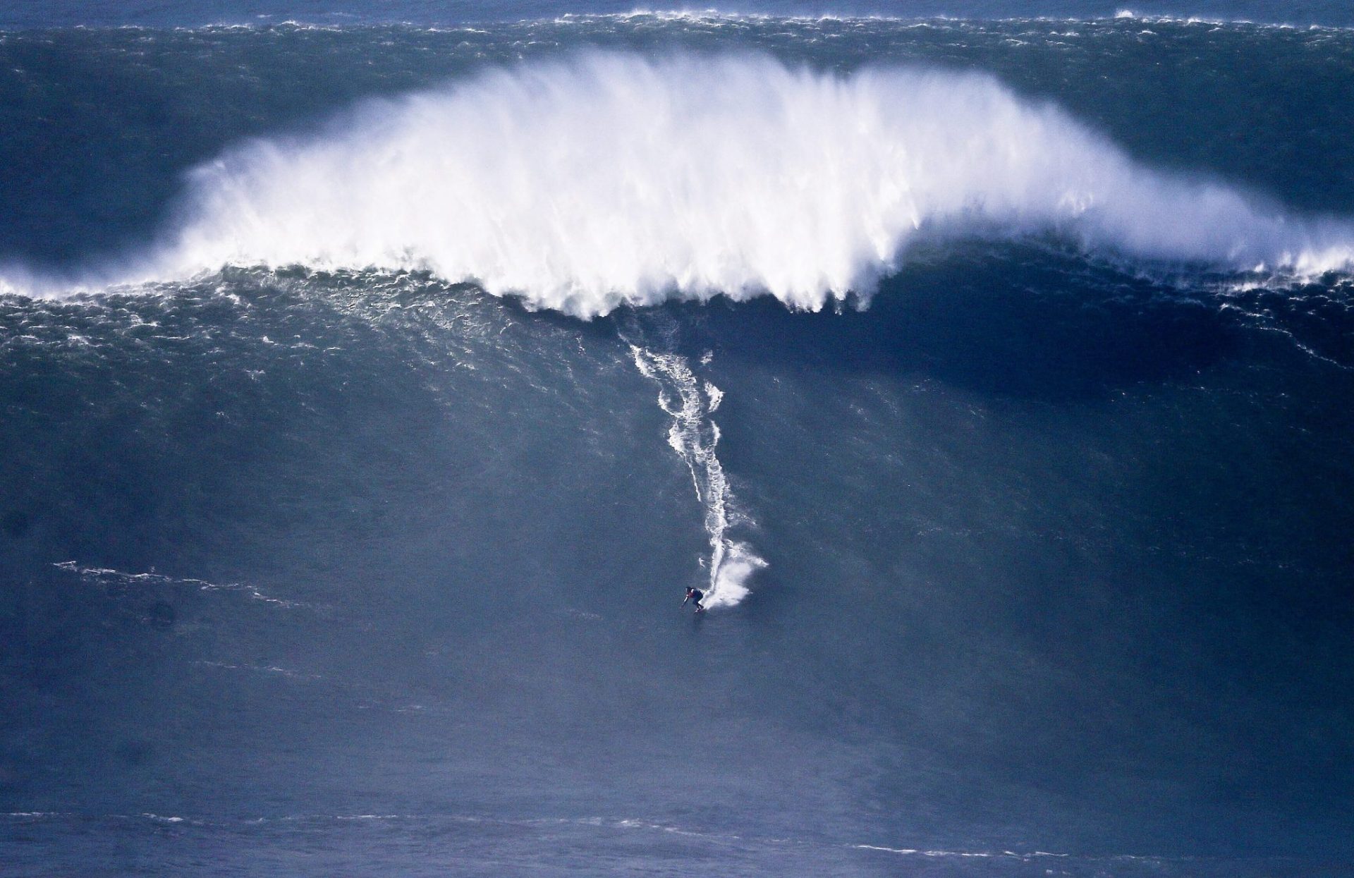 Un surfista sobre una ola en Nazaré.