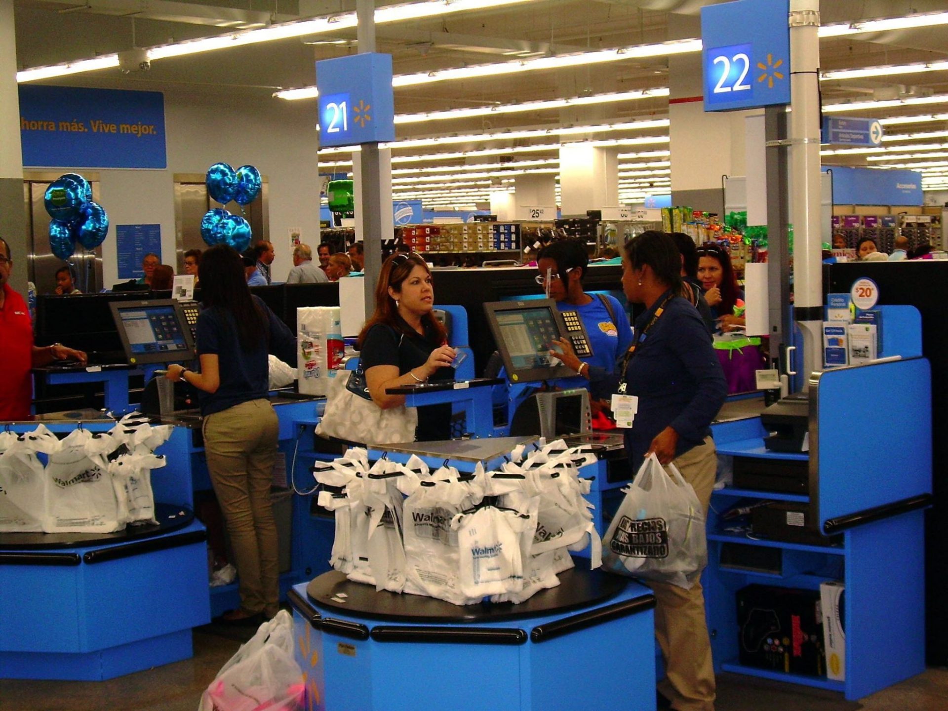 Consumidores de un supermercado de de San Juan con sus compras en bolsas de plástico.