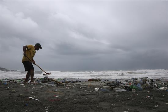 Un hombre limpia la playa de Haina (R.Dominicana), donde se registra un fuerte oleaje por efecto del paso del huracán Matthew.