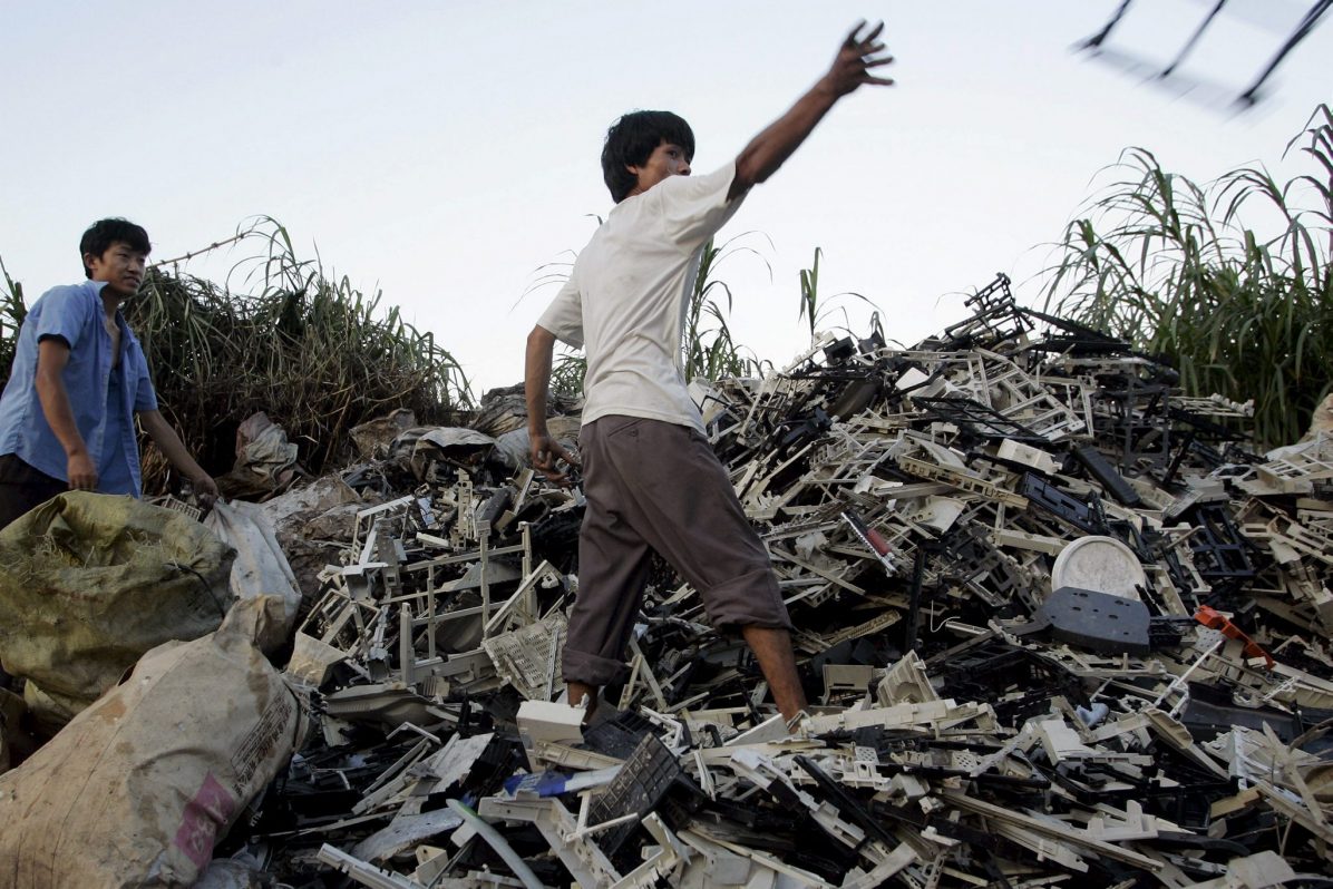 Unos trabajadores sobre una montaña de basura electrónica.EFE/Michael Reynolds