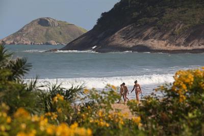 Varias personas en la playa de Grumari, en Río de Janeiro (Brasil), una de las pocas que se ha salvado de la especulación inmobiliaria. EFE/Marcelo Sayão