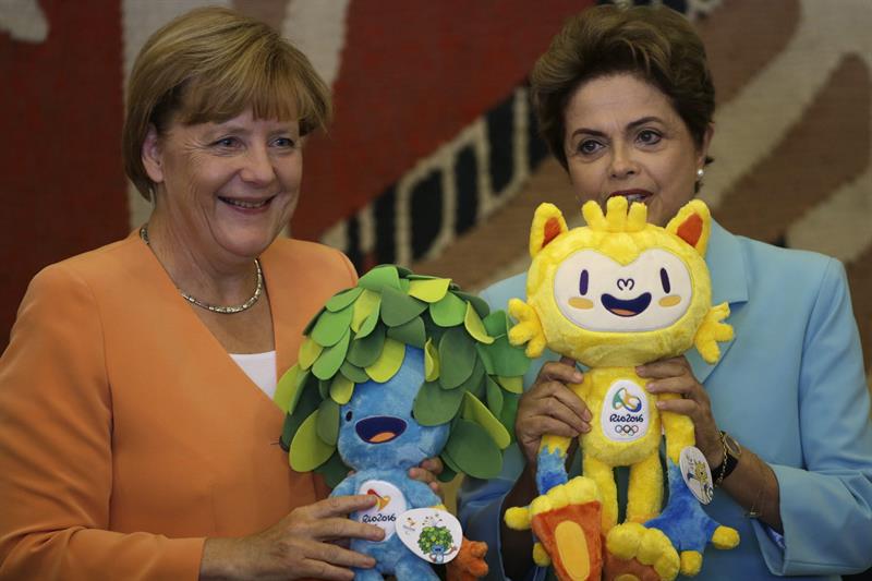 Merkel (i), recibe las las mascotas del los Juegos Olímpicos Rio 2016, "Tom" y "Vinicius", de manos de Dilma Rousseff.