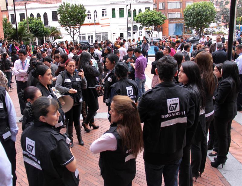 BOGOTÁ (COLOMBIA), 10/3/2015.- Empleados y habitantes del sector se reúnen tras evacuar un edificio hoy, martes 10 de marzo de 2015, en Bogotá (Colombia). Un fuerte sismo de 6,6 grados de intensidad en la escala de Richter sacudió en la tarde de hoy la mayor parte del territorio colombiano, incluida Bogotá. EFE/ Martín García