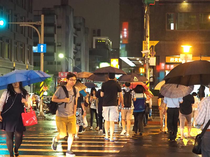 Los paraguas salen a la ciudad de Taipei por las lluvias del tifón, que ha dejado dos muertos y graves daños materiales. 