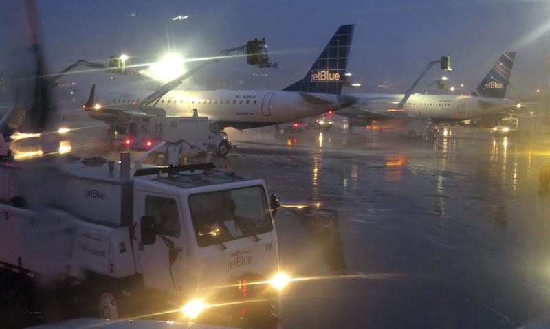 Unos operarios utilizan un soplete especial para derretir el hielo del fuselaje de un avión en el aeropuerto Logan de Boston (Massachusetts, Estados Unidos) este 9 de diciembre de 2013
