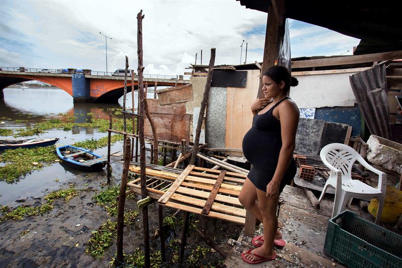 Una embarazada en la puerta de su vivienda al lado del río en Recife. 
