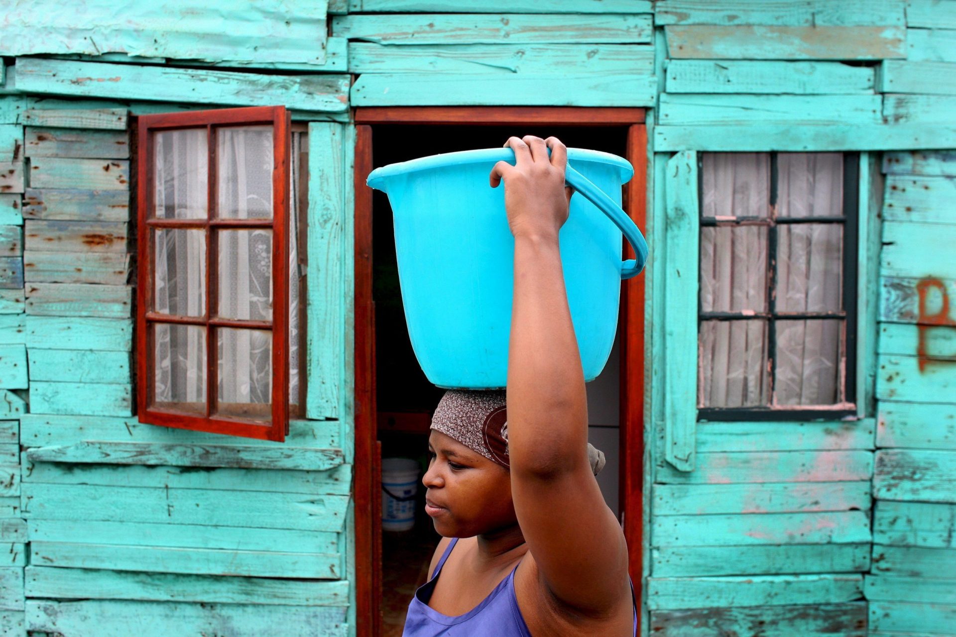 Una joven sostiene un barreño de agua en la cabeza.