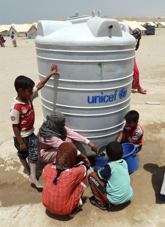 Un grupo de niños recoge agua en el campamento de refugiados de Habbaniyah, cerca de Faluya (Irak) 