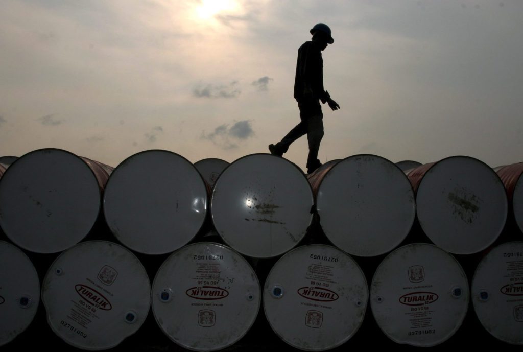 Un trabajador inspecciona barriles de petróleo en una central de distribución en Yakarta (Indonesia).